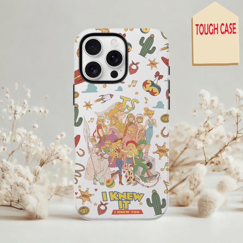 May include: A white phone case featuring a colorful collage of illustrated characters and icons including cacti, sheriff stars, rockets, and musical notes. The text "I KNEW IT" is printed in yellow and red near the bottom of the phone case.