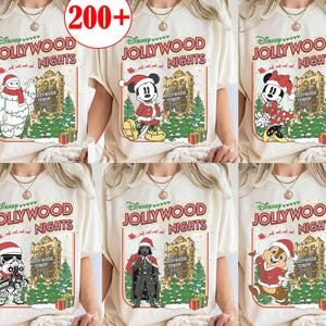 Może przedstawiać: Kremowe koszulki z postaciami Disneya w świątecznych strojach. Każda koszulka zawiera napis "Disney JOLLYWOOD NIGHTS" z świątecznym motywem, w tym choinką i Hollywood Tower.