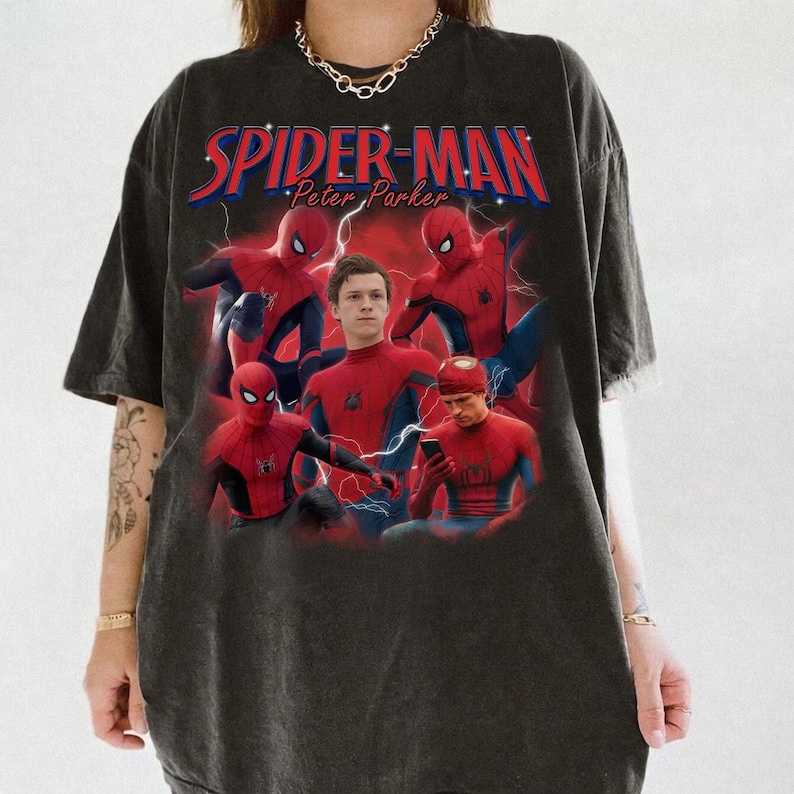 Może przedstawiać: Ciemnoszara koszulka z grafiką Spider-Mana w r&oacute;żnych pozach, z napisem "SPIDER-MAN Peter Parker" w kolorze czerwonym i niebieskim. Projekt zawiera błyskawice i wiele wizerunk&oacute;w superbohatera.