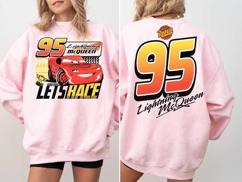 May include: A light pink sweatshirt featuring Lightning McQueen from the Cars movie. The front graphic includes the number 95, the character's name, and the phrase "Let's Race." The back displays a large number 95 and the character's name.