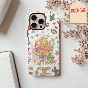 May include: A white phone case featuring a colorful collage of various illustrated characters and western-themed icons like cacti, sheriff stars, and bandanas. The text TS appears at the top, with I KNEW IT I KNEW YOU printed at the bottom.