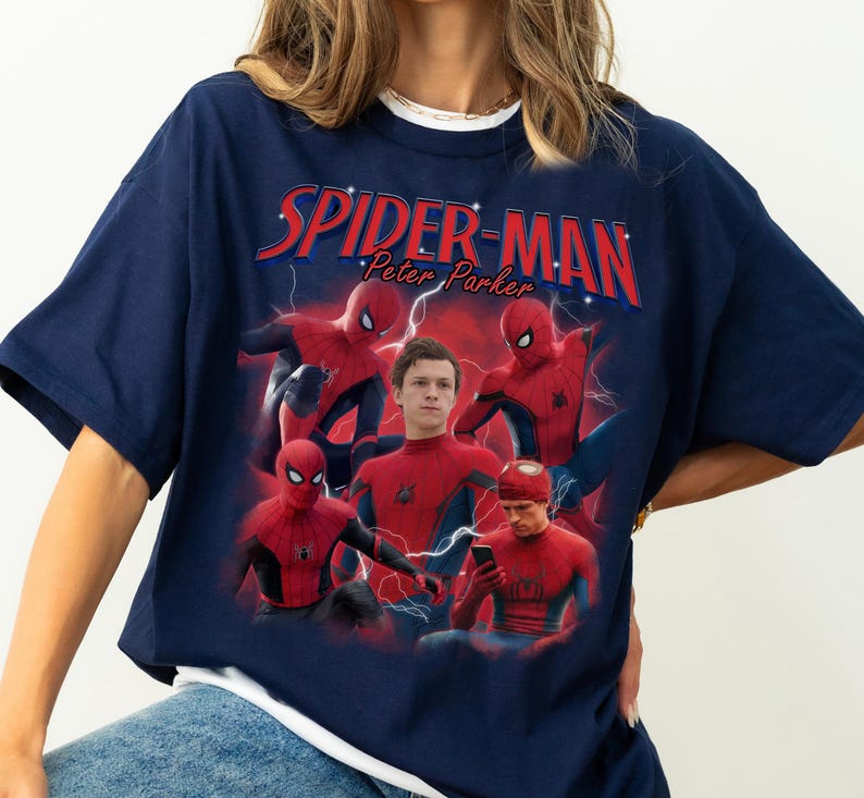Może przedstawiać: Granatowa koszulka z grafiką Spider-Mana i napisem "SPIDER-MAN Peter Parker" w kolorze czerwonym i białym. Projekt zawiera wiele obraz&oacute;w Spider-Mana w pozach akcji z niebieskim efektem błyskawicy.