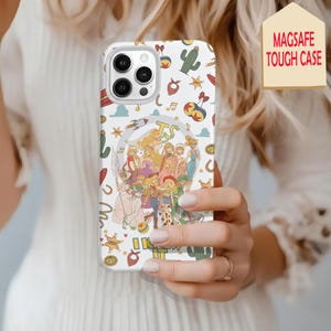 May include: A white smartphone case featuring a MagSafe design and a colorful pattern of cartoon characters, cacti, stars, and musical notes. The central graphic displays a group of animated figures with the text TS and I KNEW IT printed below.