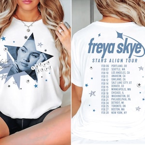 May include: White t-shirt featuring a blue star graphic with a portrait and the text "Silent Treatment" and "Freya Skye". The back of the shirt displays "Freya Skye Stars Align Tour" with a list of tour dates and locations in blue.