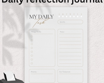 May include: A white daily reflection journal with the text "Daily reflection journal" at the top. The journal has sections for "Things To Do", "Notes", "Priority", and "For Tomorrow". The journal also has the text "MY DAILY Task" and a space for the date.