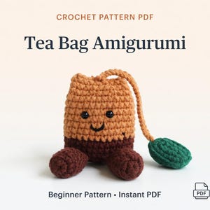 Könnte beinhalten: Gehäkeltes Teebeutel-Amigurumi mit einem lächelnden Gesicht, braunem Körper und dunkelbraunen Füßen. Der Teebeutel hat ein grünes Blatt und eine Schlaufe. Der Text auf dem Bild lautet "CROCHET PATTERN PDF" und "Tea Bag Amigurumi".