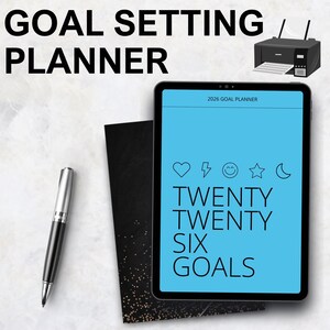 Pode incluir: Um tablet digital exibindo "TWENTY TWENTY SIX GOALS" em uma tela azul, com ícones e o texto "2026 GOAL PLANNER". Uma caneta preta e um caderno preto estão ao lado do tablet. As palavras "GOAL SETTING PLANNER" estão no topo.