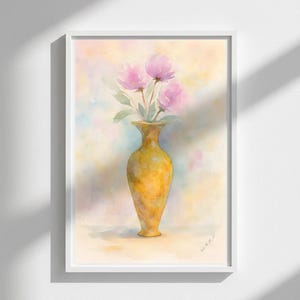 May include: Watercolor painting of a yellow vase holding pink flowers with green leaves. The vase is centered in a white framed print against a soft, pastel background. The artwork is signed in the lower right corner.