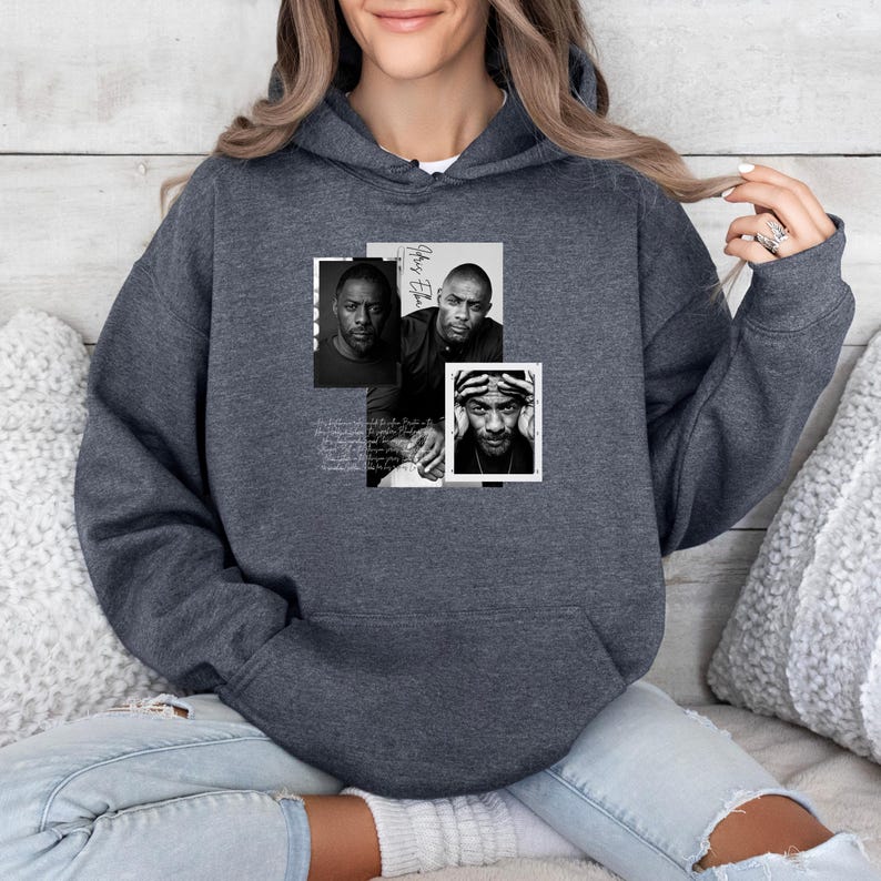 May include: Dark gray hoodie with a graphic design featuring three black and white portraits of a man. The portraits are arranged in a rectangular collage, with handwritten text in the background. The hoodie has a drawstring hood and a kangaroo pocket.
