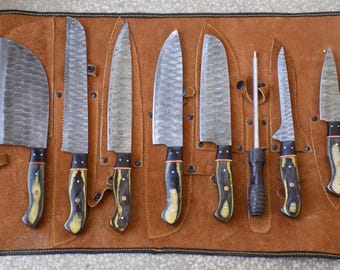 May include: A set of nine kitchen knives with black and yellow handles, including a chef's knife, a paring knife, and a sharpening steel, all rolled up in a brown leather case.