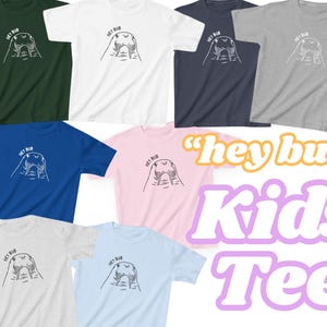 May include: A collection of t-shirts in various colors, including green, white, navy, and pink. Each shirt features a graphic of a walrus with the text "hey bub". The words "Kids Tee" are also displayed.