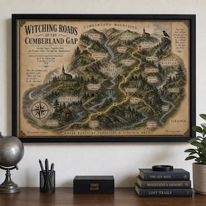 May include: A framed vintage-style map titled Witching Roads of the Cumberland Gap, featuring detailed illustrations of mountains, forests, a compass rose, and text labels. The map depicts the Cumberland Gap region with paths, landmarks, and terrain.