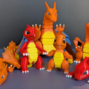 May include: A collection of seven orange and red articulated dragon figurines. The dragons are made of plastic and have a segmented design.