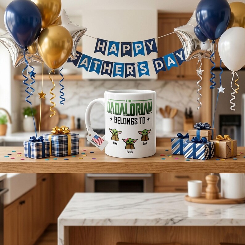 May include: A white ceramic mug featuring the text THE DADALORIAN BELONGS TO and three cartoon alien characters with the names Mike, Emily, and Jack printed below them. A small tag with a US flag is attached to the handle of the mug.
