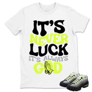 Puede incluir: Camiseta blanca con el texto "IT'S NEVER LUCK IT'S ALWAYS GOD" en negro, verde ne&oacute;n y gris. El dise&ntilde;o incluye manos rezando. Un par de zapatillas grises, negras y verde ne&oacute;n en la parte inferior.