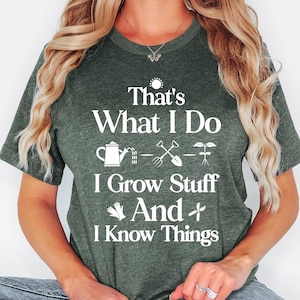 May include: Heather forest green t-shirt with the text "That's What I Do, I Grow Stuff And I Know Things" in white. The shirt features gardening-related icons. The shirt is a crew neck and has short sleeves.