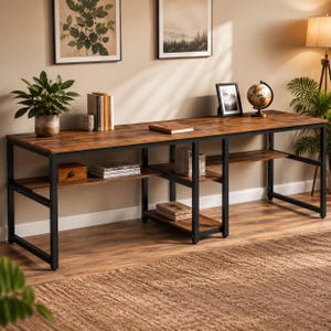May include: A long, rectangular desk featuring a dark wood-grain surface and a black metal frame. The desk includes multiple open storage shelves integrated into the base, providing space for books, a small wooden box, and various decorative items.