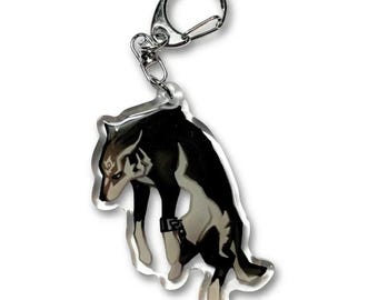 May include: A clear acrylic keychain featuring a stylized illustration of a black and white wolf with a dark marking on its forehead. The wolf is depicted in a downward-facing pose with a metal lobster claw clasp attached to the top of the charm.