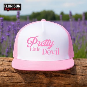 May include: A white and pink trucker hat with the text "Pretty Little Devil" in pink script. The hat has a pink brim and mesh back, with the brand logo "Florisun Signature" in the top left corner.