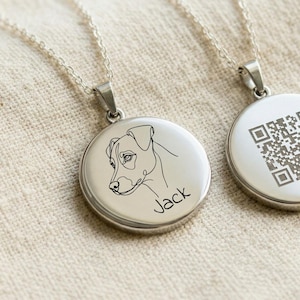 Peut inclure: Deux colliers pendentifs argentés pour chien. L'un des pendentifs présente un dessin au trait de la tête d'un chien et le nom "Jack" en écriture cursive. L'autre pendentif porte un code QR. Les deux sont sur des chaînes délicates.