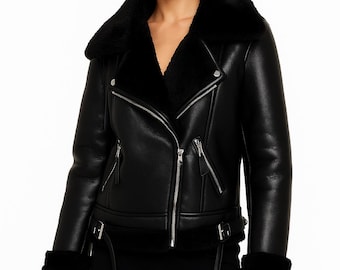 May include: Black leather jacket with a shearling collar and cuffs. The jacket features a zip-up front, multiple pockets, and a belt detail at the waist. A stylish outerwear piece for colder weather.