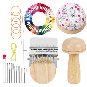 Może przedstawiać: Zestaw materiałów do szycia i rękodzieła. Zawiera kwiatową poduszkę na szpilki, drewniane narzędzie w kształcie grzyba, wielokolorowe nici do haftu, igły i narzędzie do tkania. Widoczne są również gumki recepturki i mała probówka.