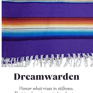 May include: A vibrant purple textile with horizontal stripes in shades of red, orange, yellow, and blue. The bottom edge features white fringe. The word "Dreamwarden" is displayed below the textile, along with the text "Honor what rises in stillness. That is where true wisdom begins."