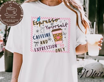 以下が含まれることがあります： 「Espresso Yourself, Caffeine and Expression Only」と書かれたカラフルなグラフィックの白いTシャツ。デザインには、ヒョウ柄のハート、蝶、花が入ったコーヒーカップが含まれています。シャツには筆記体で「White」という文字も入っています。