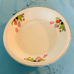 Może przedstawiać: Biała ceramiczna miska z pozłacanym brzegiem i kwiatowym wzorem przedstawiającym różowe, pomarańczowe i zielone tulipany.