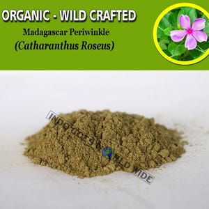 May include: A mound of finely ground, light brown powder, possibly an herbal product, is on a white surface. The image includes text: "ORGANIC - WILD CRAFTED" and "Madagascar Periwinkle (Catharanthus Roseus)". A circular inset shows a pink flower.