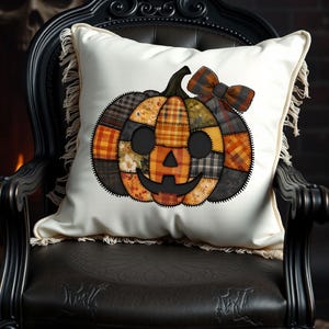 Może przedstawiać: Biała poduszka dekoracyjna z patchworkowym wzorem dyni. Dynia ma uśmiechniętą twarz i kratkowaną kokardę. Dynia wykonana jest z różnych pomarańczowych, żółtych i brązowych tkanin, idealna do jesiennej dekoracji.