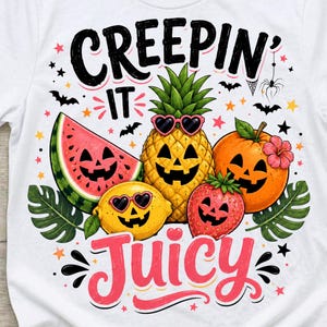 May include: A white t-shirt featuring a graphic of a watermelon slice, pineapple, lemon, strawberry, and orange, all with carved jack-o'-lantern faces. The text reads "CREEPIN' IT JUICY" in black and pink, surrounded by bats, stars, and green leaves.