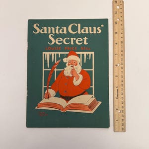 May include: Vintage book cover titled "Santa Claus' Secret" by Louise Price Bell. The cover features an illustration of Santa Claus writing in a book, with a green background and a window design.