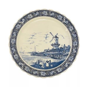 May include: A white ceramic plate with a blue and white design of a windmill and a Dutch village scene. The plate has a scalloped edge and a blue floral border.