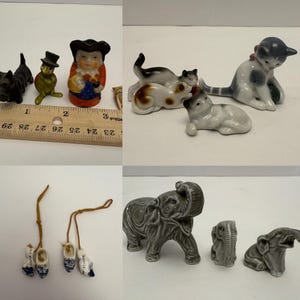 Könnte beinhalten: Eine Sammlung kleiner Keramikfiguren, darunter Katzen, Elefanten und holländische Holzschuhe. Die Figuren sind in verschiedenen Farben gehalten, darunter Schwarz, Weiß, Grau und Blau. Ein Lineal dient als Maßstab.