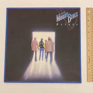 May include: A vinyl record album cover for "Octave" by The Moody Blues. The album art shows the band members walking towards a bright light. The album cover is framed in blue, with the band's name and album title in white.