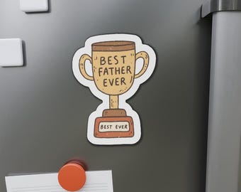 May include: A magnet featuring a cartoon trophy with the text "BEST FATHER EVER" on the cup and "BEST EVER" on the base. The trophy is brown and tan with a white outline, set against a gray background with other magnets.