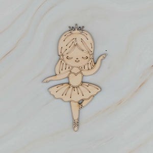 May include: Wooden cutout of a ballerina with a crown. The ballerina is in a dancing pose, with one leg extended and arms gracefully curved. The design features a tutu and ballet slippers, perfect for crafts or decor.
