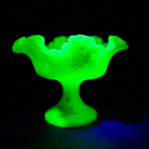 Vintage 7.75” Uranium Glow Custard Art Glass Ruffled and Crimped Fenton Compote with Hand Painted Ranunculus - Signed by Artist S. Hart