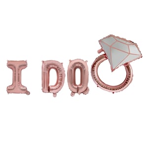 May include: Rose gold foil balloons spelling "I DO" with a diamond ring balloon. The balloons are inflated and arranged on a white background. The diamond ring balloon has a white diamond shape with rose gold accents.