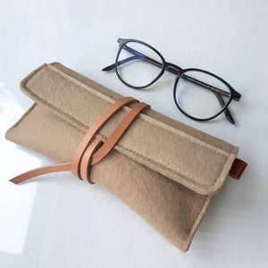 Soft wool felt case for reading glasses in toffee beige featuring a unique leather wrap closure