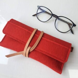 Soft mango red wool felt case for reading glasses featuring a unique leather wrap closure