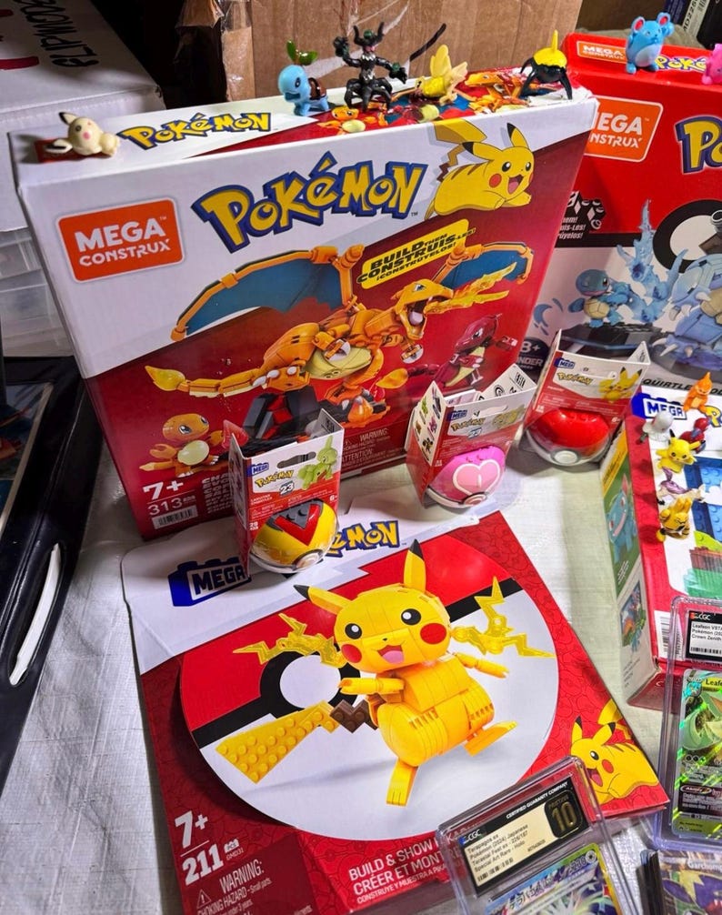 Puede incluir: Una colecci&oacute;n de sets de construcci&oacute;n y figuras de Pok&eacute;mon de Mega Construx. Las cajas son rojas y blancas, con Pikachu y otros personajes. Una figura de Pikachu est&aacute; montada sobre una base roja y blanca con el tema de la Pok&eacute; Ball. Se muestran varias figuras de Pok&eacute;mon.