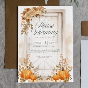 Peut inclure: Invitation de pendaison de crémaillère avec un design à l'aquarelle. L'invitation présente une porte blanche avec des accents floraux, des citrouilles et le texte "House Warming Celebration". La date et l'heure sont également incluses.