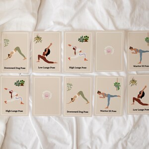 May include: Set of eight illustrated yoga pose cards with a beige background and green plant illustrations. The cards feature a woman in each pose with the name of the pose written below. The poses include Downward Dog, Low Lunge, High Lunge, and Warrior III.