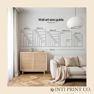 May include: A wall art size guide with different ratios and dimensions in inches and centimeters. The guide shows the different sizes of prints available for a variety of wall art sizes. The guide is displayed on a white wall with a light brown wooden floor. A light brown wicker cabinet and a white sofa with a beige throw blanket are in the foreground.