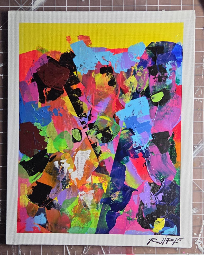 May include: Abstract acrylic painting on canvas with a white border. The artwork features bold brushstrokes in vibrant colours including yellow, blue, pink, purple, and black. The artist's signature is in the bottom right corner.