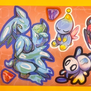 Puede incluir: Una hoja de pegatinas con personajes de dibujos animados en azul, amarillo y negro. Los personajes incluyen una figura azul grande, una pequeña criatura amarilla con alas rosas y un personaje negro con acentos rojos. El fondo es marrón claro con ilustraciones de gemas.