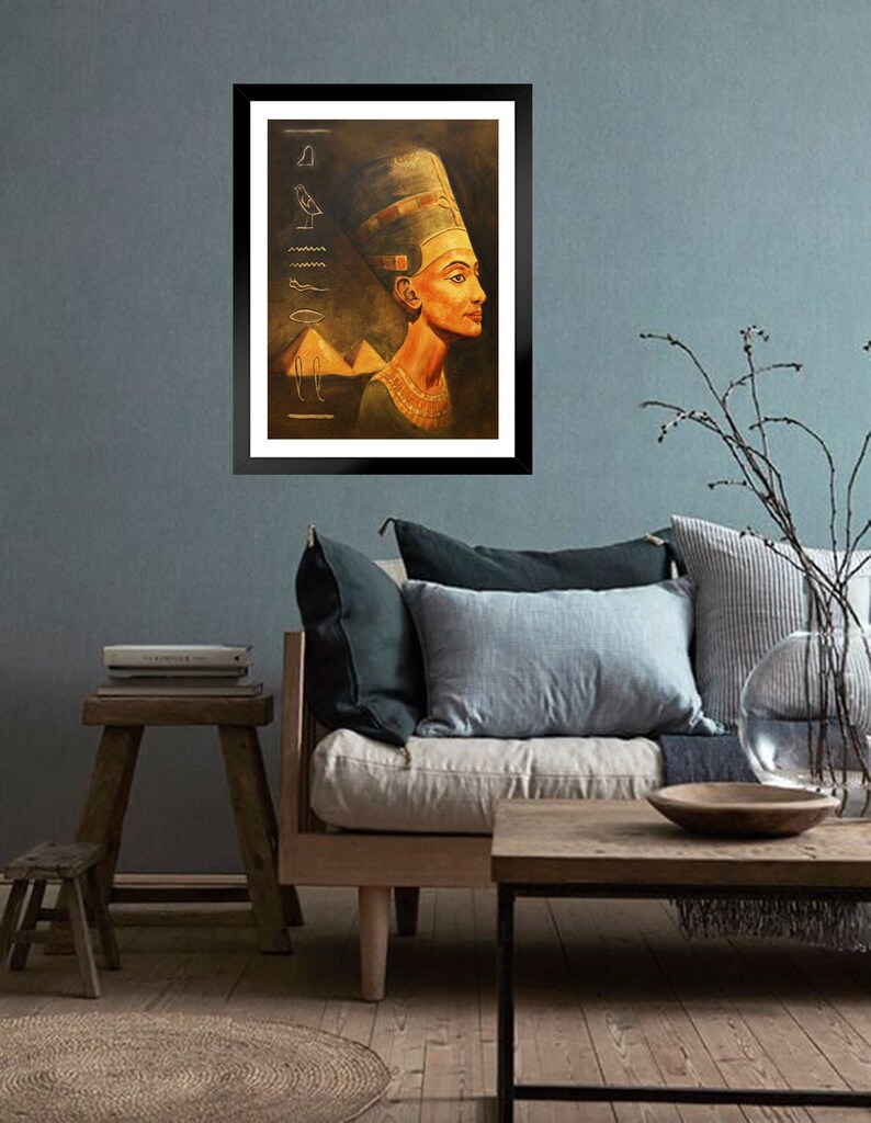 May include: A framed painting of an Egyptian queen wearing a golden headdress and a necklace. The background is a dark brown with hieroglyphics and a pyramid.