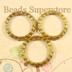 May include: Three gold-colored metal rings with a textured, hammered surface pattern. The rings are arranged in a triangular formation. The text "Beads Superstore" is visible at the top of the image in a dark brown, serif font.